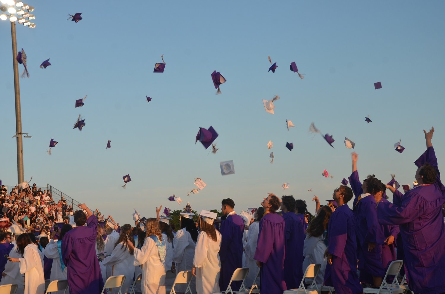 Graduates from Islip High School’s Class of 2022 celebrate and toss their caps after the graduation ceremony.